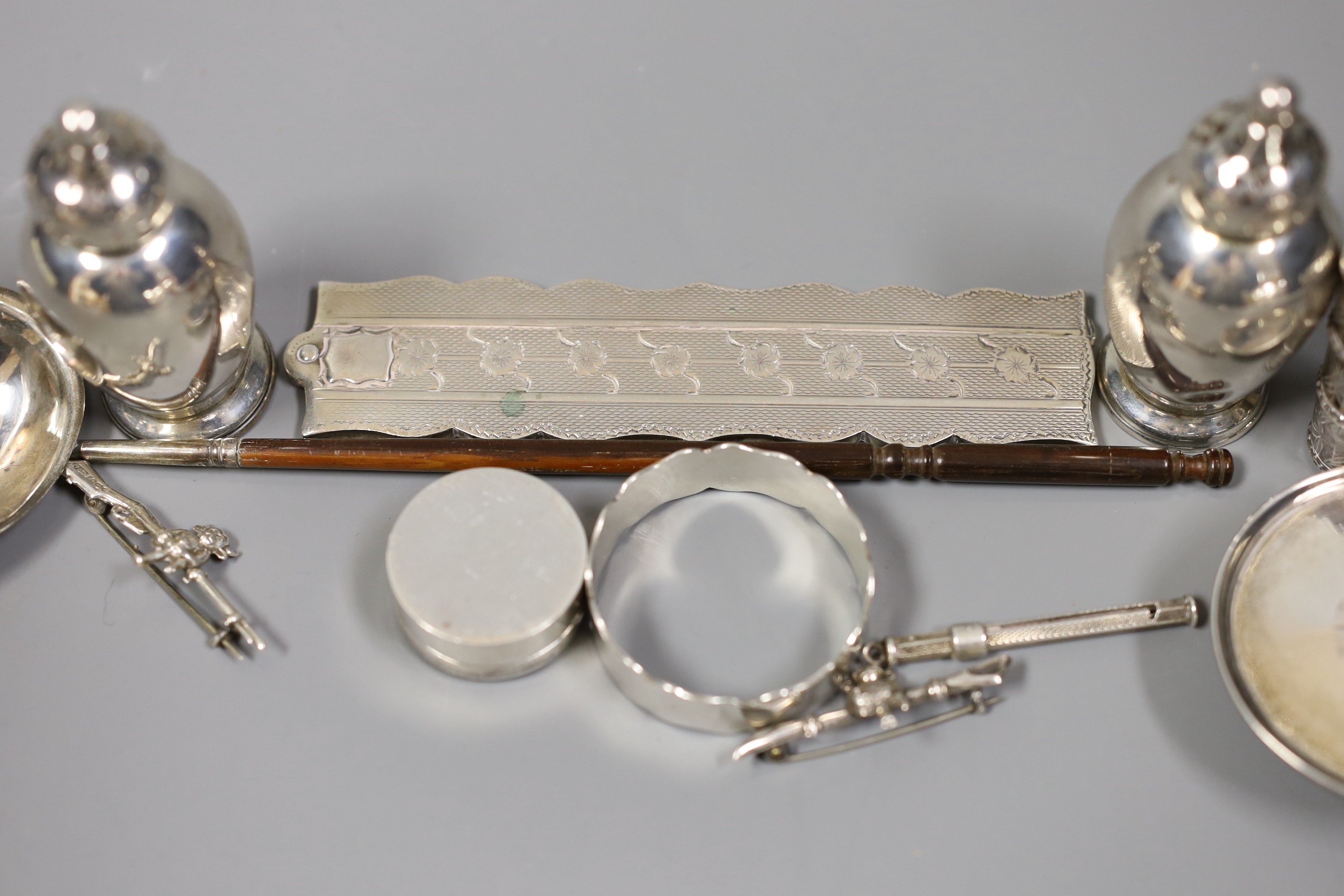 A quantity of small silver or white metal items including a long handled server spoon, Chinese pepperette, pair of Victorian pepperettes, Victorian silver paten, 19th century toddy ladle by Taylor & Perry, folding comb,